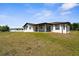 A wide shot of the back exterior of the house and backyard at 3315 Elkcam Blvd, Port Charlotte, FL 33952