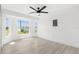Airy bedroom featuring wood-look tile floors, a modern ceiling fan, and a window overlooking the yard at 3315 Elkcam Blvd, Port Charlotte, FL 33952
