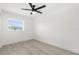 This bedroom features wood-look tile floors, a ceiling fan and a window at 3315 Elkcam Blvd, Port Charlotte, FL 33952