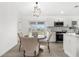 Cozy dining area with a round table, four chairs, and natural light streaming through sliding glass doors at 3315 Elkcam Blvd, Port Charlotte, FL 33952