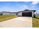 Charming single-story home featuring a dark brown roof and garage door with a long driveway at 3315 Elkcam Blvd, Port Charlotte, FL 33952