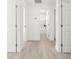 Bright hallway with wood-look tile floors leading to a bathroom with tub and marble tile surround at 3315 Elkcam Blvd, Port Charlotte, FL 33952