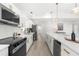 Modern kitchen featuring white cabinets, stainless steel appliances, and a large island with a wine cooler at 3315 Elkcam Blvd, Port Charlotte, FL 33952