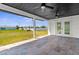 A covered patio with an outdoor fan and views of a spacious backyard at 3315 Elkcam Blvd, Port Charlotte, FL 33952