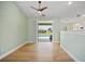 Bright living room with wood-look tile flooring, a modern ceiling fan, and views of the screened pool area at 347 Casale G St, Punta Gorda, FL 33983