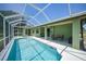 Backyard screened-in pool with attached patio and view of the home's exterior at 347 Casale G St, Punta Gorda, FL 33983