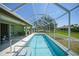 Screened-in pool with clear blue water, patio seating, and green exterior of the home at 347 Casale G St, Punta Gorda, FL 33983