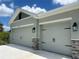 Spacious three-car garage with modern doors and decorative stone accents, providing ample parking and storage at 411 Paramaribo St, Punta Gorda, FL 33983