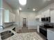 Modern kitchen featuring stainless appliances, granite countertops, white cabinets, and wood-look flooring at 411 Paramaribo St, Punta Gorda, FL 33983