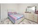 Comfortable bedroom with a queen-size bed, dresser, and decorative mirror at 4213 Gardner Dr, Port Charlotte, FL 33952