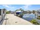 View of a concrete boat dock on a sunny day, including a boat lift at 4213 Gardner Dr, Port Charlotte, FL 33952