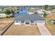 Aerial front view of home with canal access, a paved driveway, and manicured lawn at 4213 Gardner Dr, Port Charlotte, FL 33952