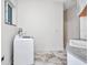 Bright laundry room with marble-look tile floors, a washer and dryer, and overhead lighting at 4213 Gardner Dr, Port Charlotte, FL 33952