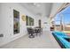 Covered outdoor patio with dining set, ceiling fans, and access to the pool and backyard at 4213 Gardner Dr, Port Charlotte, FL 33952