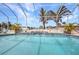 Screened-in pool with tile waterfall feature, tropical landscaping, and a view of the waterfront at 4213 Gardner Dr, Port Charlotte, FL 33952
