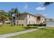 Exterior shot of beige building with lush green grass and palm trees at 5800 Sabal Trace Dr # 1302, North Port, FL 34287