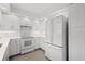 Bright kitchen featuring white cabinetry and modern appliances including a stove and refrigerator at 5800 Sabal Trace Dr # 1302, North Port, FL 34287