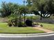Landscaping in the roundabout features palm trees, shrubs, brick pavers, and an umbrella at 5800 Sabal Trace Dr # 1302, North Port, FL 34287
