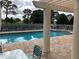 Community pool with lounge chairs and views of lush greenery at 5800 Sabal Trace Dr # 1302, North Port, FL 34287