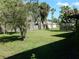 Large, grassy backyard with mature trees and a wooden fence at 582 Reading Nw St, Port Charlotte, FL 33952