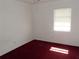 Bright bedroom with a window to let in natural light and red carpeting at 582 Reading Nw St, Port Charlotte, FL 33952