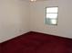 Cozy bedroom featuring a window for natural light and red carpeting at 582 Reading Nw St, Port Charlotte, FL 33952