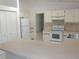 The kitchen is equipped with white appliances, laminate countertops, and tiled floors at 582 Reading Nw St, Port Charlotte, FL 33952
