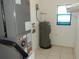 Utility room featuring an HVAC system, water heater, and window for light at 582 Reading Nw St, Port Charlotte, FL 33952