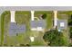 An aerial view shows three houses with grey roofs and long driveways surrounded by green grass and sparse vegetation at 582 Ridgewood Nw St, Port Charlotte, FL 33952