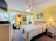 Comfortable bedroom with yellow walls, view, ceiling fan, workspace, and a large bed at 582 Ridgewood Nw St, Port Charlotte, FL 33952