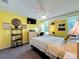 Inviting bedroom featuring yellow walls, ceiling fan, a view, plus workspace and entertainment at 582 Ridgewood Nw St, Port Charlotte, FL 33952