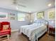 Bedroom features a comfortable bed, accent chair, and ample natural light from the windows at 582 Ridgewood Nw St, Port Charlotte, FL 33952