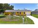 Delightful single-Gathering home featuring a vibrant yellow exterior, attached garage, and verdant front yard at 582 Ridgewood Nw St, Port Charlotte, FL 33952