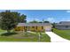 Inviting single-Gathering home with a bright yellow exterior, well-manicured lawn, and a welcoming entryway at 582 Ridgewood Nw St, Port Charlotte, FL 33952