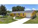 Charming single-Gathering home featuring a sunny yellow exterior, attached garage, and landscaped front yard at 582 Ridgewood Nw St, Port Charlotte, FL 33952