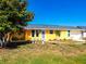 Well-maintained house with yellow exterior, lush lawn, and inviting curb appeal at 582 Ridgewood Nw St, Port Charlotte, FL 33952
