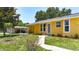 Charming single-Gathering home with a vibrant yellow exterior and well-maintained front yard at 582 Ridgewood Nw St, Port Charlotte, FL 33952