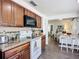 Open-concept kitchen with wood cabinetry, modern appliances, and a breakfast bar overlooking the dining area at 582 Ridgewood Nw St, Port Charlotte, FL 33952