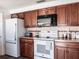 Traditional kitchen with wood cabinets, white appliances, and patterned backsplash at 582 Ridgewood Nw St, Port Charlotte, FL 33952