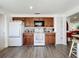 Well-lit kitchen featuring wood cabinets, modern appliances, and durable laminate wood-look flooring at 582 Ridgewood Nw St, Port Charlotte, FL 33952