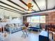 Cozy living room featuring wood paneled walls, beamed ceilings, and a bright window view at 582 Ridgewood Nw St, Port Charlotte, FL 33952