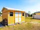 Outdoor shed with a fresh coat of yellow paint provides extra storage space at 582 Ridgewood Nw St, Port Charlotte, FL 33952