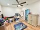 Bedroom or flex space with wood floors, window and ceiling fan, filled with personal items at 6308 Grove Blvd, Punta Gorda, FL 33982