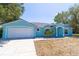 Charming single-story home with a two-car garage and light blue exterior paint at 6308 Grove Blvd, Punta Gorda, FL 33982