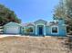 Charming single-Gathering home with a blue exterior, blue front door, white trim, and well-manicured landscaping at 6308 Grove Blvd, Punta Gorda, FL 33982
