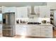 Modern kitchen featuring stainless steel appliances, island, and sleek white cabinetry at 6308 Grove Blvd, Punta Gorda, FL 33982