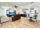 Spacious living room with wood-look flooring, a ceiling fan, and an open view of the modern kitchen at 6308 Grove Blvd, Punta Gorda, FL 33982