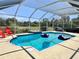 Screened-in pool with comfortable seating, a jacuzzi, and lush landscaping at 6308 Grove Blvd, Punta Gorda, FL 33982