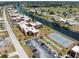Aerial view showcasing condos, tennis courts, parking, & waterfront canal in the community at 72 Boundary Blvd # 226, Rotonda West, FL 33947