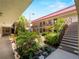 Exterior view of a condominium building with a garden courtyard and staircase at 72 Boundary Blvd # 226, Rotonda West, FL 33947